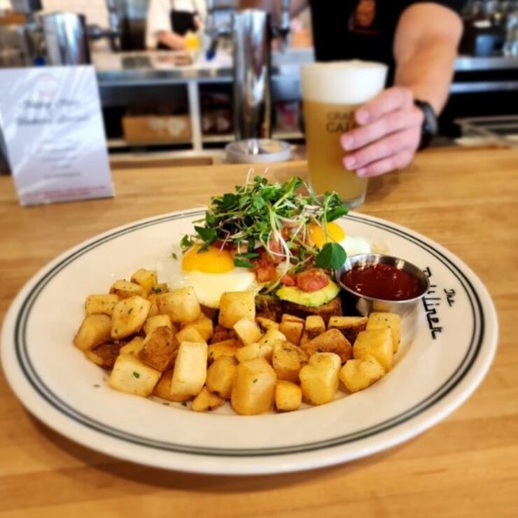 best brunch in calgary A mouth-watering brunch setting with sunny-side-up eggs, golden crispy potatoes, and a beer at The Beltliner in Calgary. Best brunch in calgary