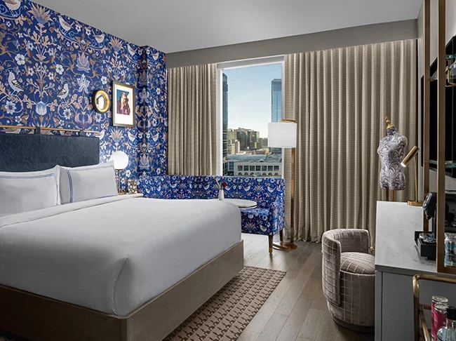 a room with a bed and a blue wallpaper. Boutique hotels calgary.